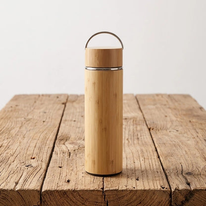 Gourde en bambou isotherme zen, finition avec anse métallique, coque en bambou naturel, sur bois brut