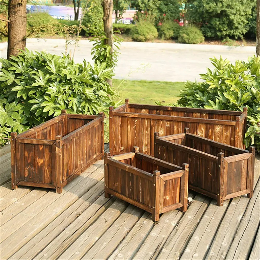 Jardinière surélevée en bois brun foncé, les 4 tailles disponibles côte à côte sur une terrasse extérieure