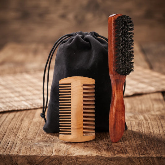 Peigne en bois, pochon noir et brosse à manche long en poils de sanglier posés sur une table en bois