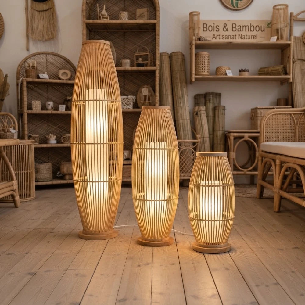 Trois lampadaires bambou fuseau de tailles différentes allumés sur un parquet