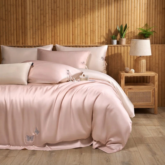 Parure de lit en bambou brodée rose poudré sur un lit