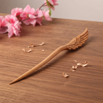 Pic à cheveux en bois de pêcher sculpté motif aile déployée, bois naturel beige artisanal