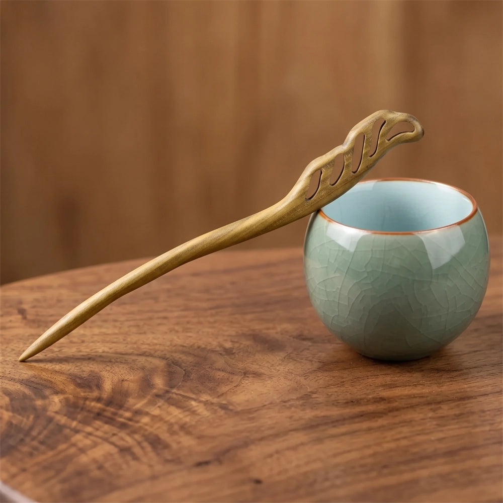 Pic à cheveux en bois de santal vert à motif vagues ajourées sculpté, posé sur une tasse en céramique