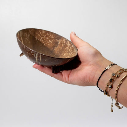 Porte-savon en noix de coco tenu dans une main, format compact