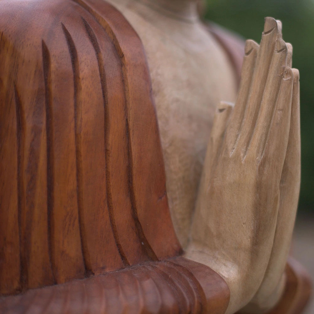Mains jointes et pli de la robe sculptés sur la statue de Bouddha en bois de Suar