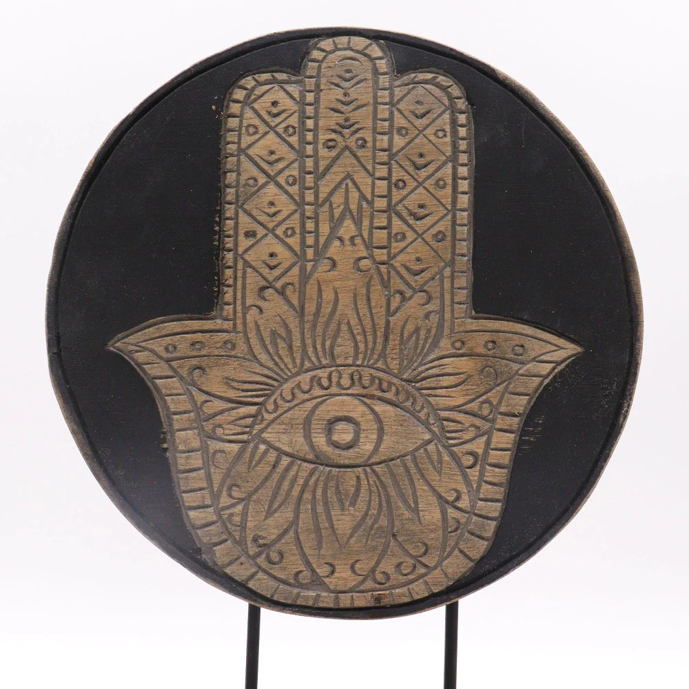 Symbole de la main de Hamsa sculpté en bois clair sur un disque noir en bois d'albasia
