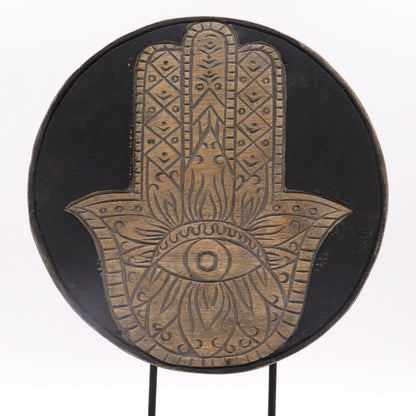 Symbole de la main de Hamsa sculpté en bois clair sur un disque noir en bois d'albasia