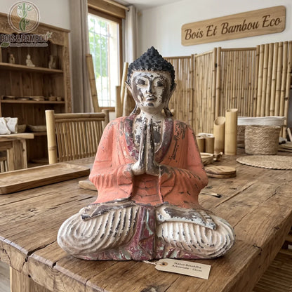 Statue de Bouddha assis vintage orange en bois de Suar, 30 cm, posée sur une table en bois dans une boutique de déco naturelle