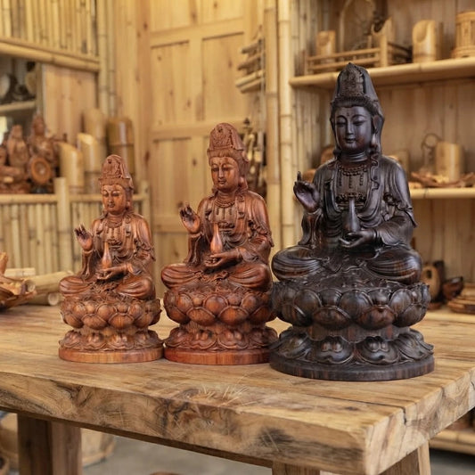 Statue Guan Yin en bois sculpté en trois tailles, deux en bois de rose et une en ébène, sur une table en bois