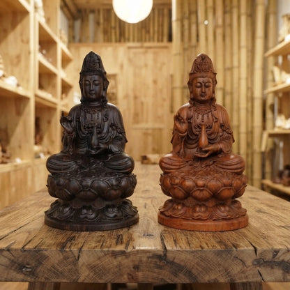 Statue Guan Yin en bois sculpté, modèles en ébène et en bois de rose côte à côte sur une table en bois