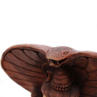 Tête du cobra sculptée au-dessus du chignon de la statue de Shiva en bois de Suar
