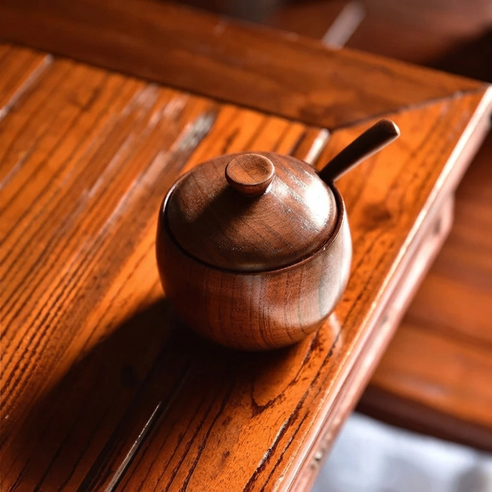 Sucrier en bois de jujubier fermé avec cuillère, posé sur un meuble en bois ancien, ambiance chaleureuse et naturelle