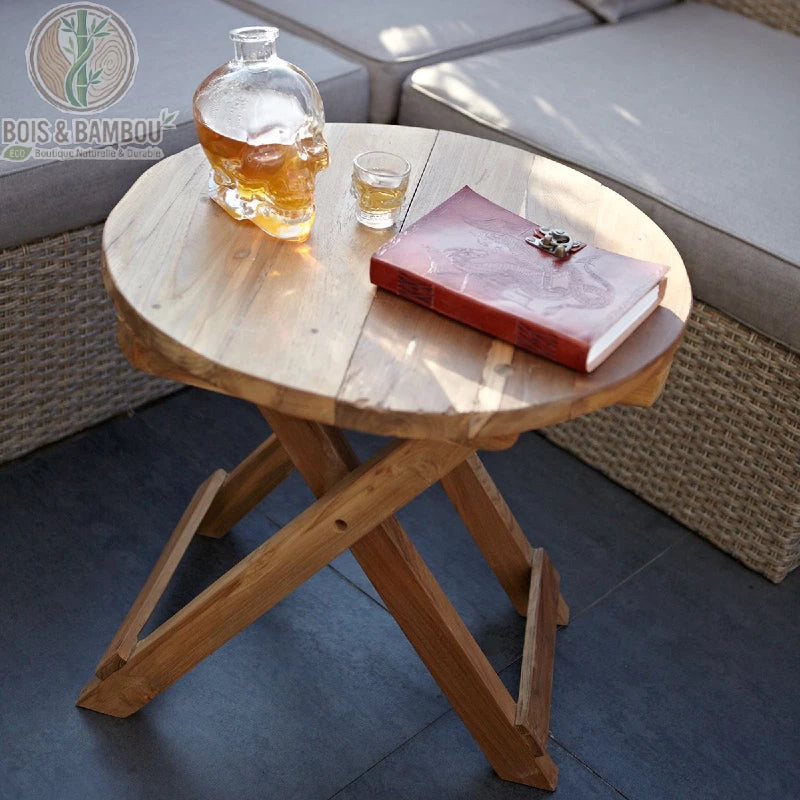Table basse ronde pliante en teck recyclé installée près d'un canapé