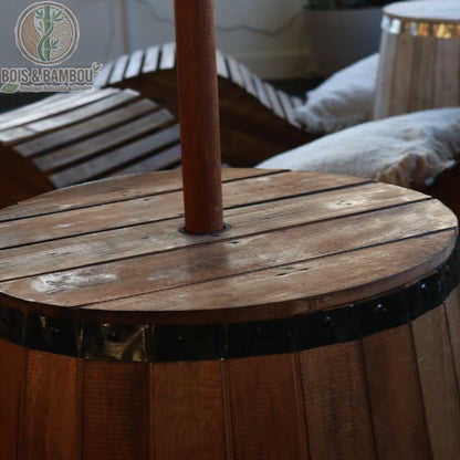 Gros plan sur le plateau de la table tonneau bois et le mât de parasol