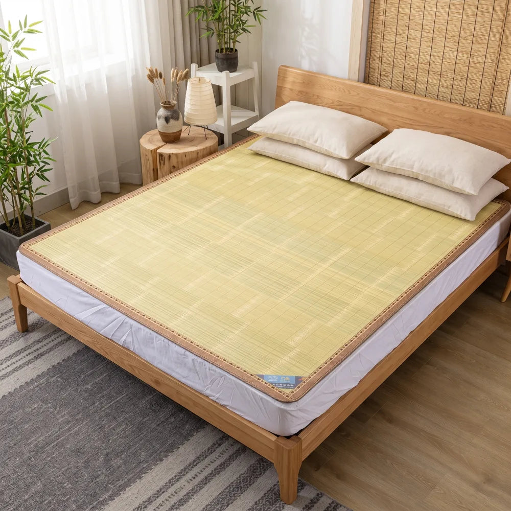Tapis de lit bambou motif bordure tressée, oreillers blancs, installé sur un lit