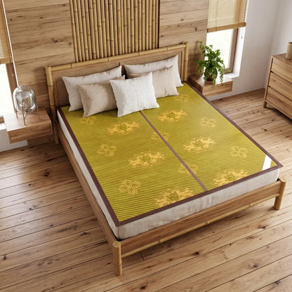 Tapis de lit bambou tressé coloris jaune moutarde à motif floral, installé sur un lit