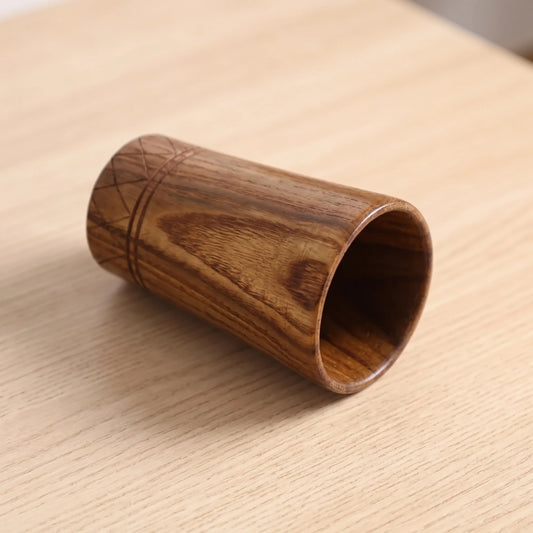 Tasse en bois couchée sur le côté, veinage brun et bande gravée en losanges visible