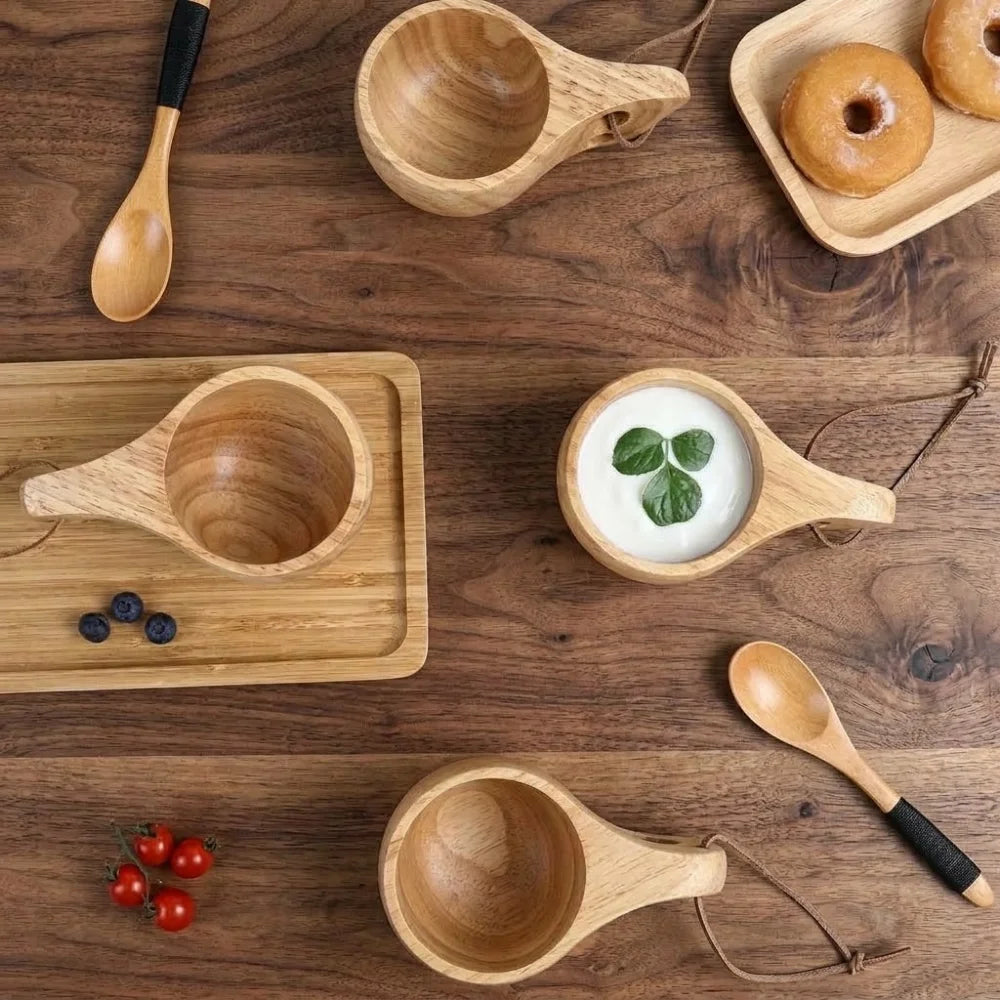 Tasses en bois style kuksa en situation sur une table en bois avec collation
