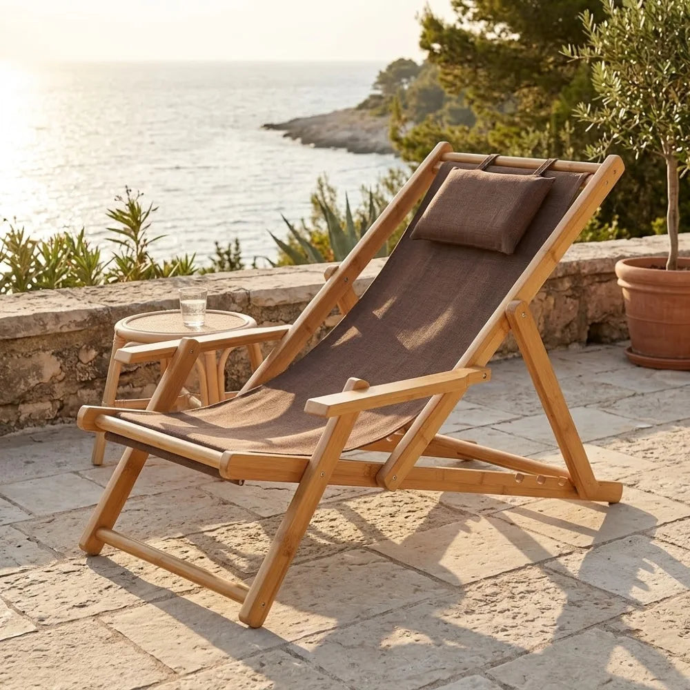 Transat en toile et bambou à accoudoirs, cadre naturel et toile marron avec coussin assorti, sur une terrasse en pierre